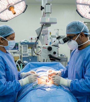 Indian spine surgeons performing microsurgical spinal tumor resection with surgical operating microscope